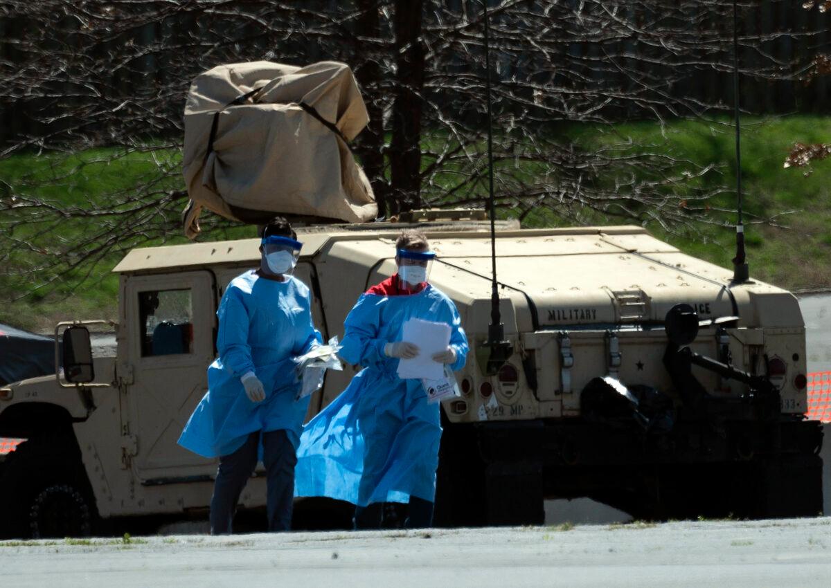 Health care professionals screen people at a testing site organized by the Maryland National Guard in a parking lot at FedEx Field in Landover, Md., on March 30, 2020. (Andrew Caballero-Reynolds/AFP via Getty Images)