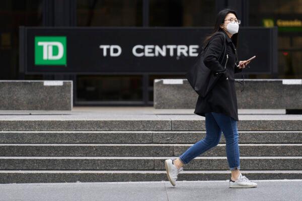 A woman in a mask walks in the financial district in Toronto, Ontario on March 24, 2020. (Geoff Robins/AFP via Getty Images)