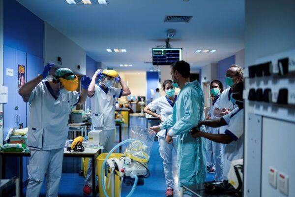 Medical workers put on protective gear before working at the unit for COVID-19-infected patients at the Erasme Hospital in Brussels on March 27, 2020. (Kenzo Tribouillard/AFP via Getty Images)