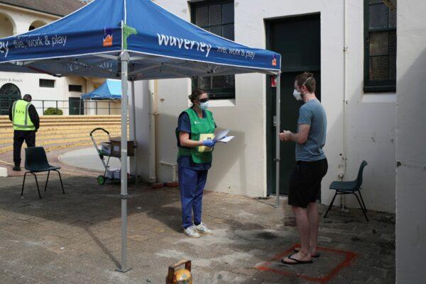 A healthcare professional talks to a man at a pop-up clinic testing for the coronavirus disease (COVID-19) at Bondi Beach, after several outbreaks were recorded in the area, in Sydney, Australia, on April 1, 2020. (Loren Elliot/ Reuters)