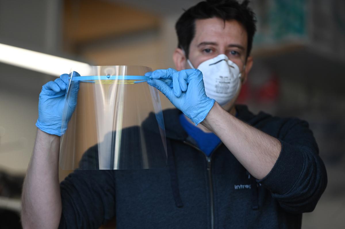 Jeremy Reitman displays a medical quality personal protective equipment (PPE) face shield for doctors and nurses that he made in his garage on 3D printers in Calabasas, California, on March 30, 2020. (Robyn Beck/AFP via Getty Images)