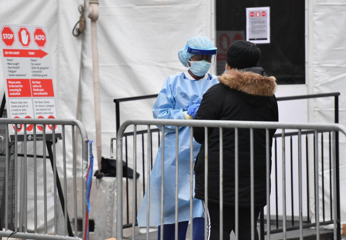 Medical staff helps a patient upon entering a COVID-19 screening tent of the Brooklyn Hospital Center in the Brooklyn borough of New York on March 31, 2020. (Angela Weiss/AFP via Getty Images)