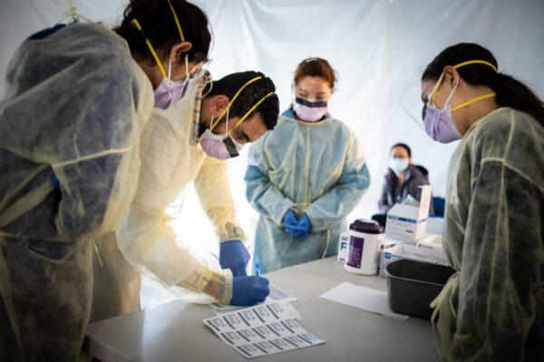 Doctors test hospital staff with flu-like symptoms for coronavirus (COVID-19) in set-up tents to triage possible COVID-19 patients outside before they enter the main Emergency department area at St. Barnabas hospital in the Bronx on March 24, 2020. (Misha Friedman/Getty Images)