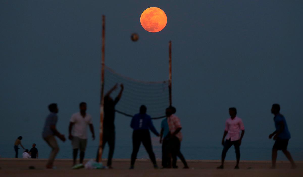 People play volleyball on the beach as the Super Pink Moon rises over the Salmiya district, east of Kuwait City, Kuwait, on April 19, 2019 (©Getty Images | <a href="https://www.gettyimages.com/detail/news-photo/people-play-volleyball-on-the-beach-as-the-pink-moon-rises-news-photo/1138066948?adppopup=true">YASSER AL-ZAYYAT</a>)