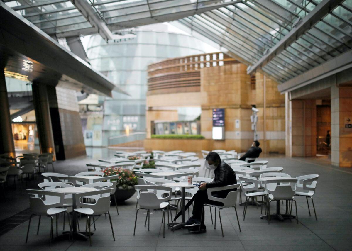People wearing protective masks take a rest among empty seats in a cafe and restaurant at the Roppongi Hills complex in Tokyo, Japan on April 1, 2020. (Issei Kato/Reuters)