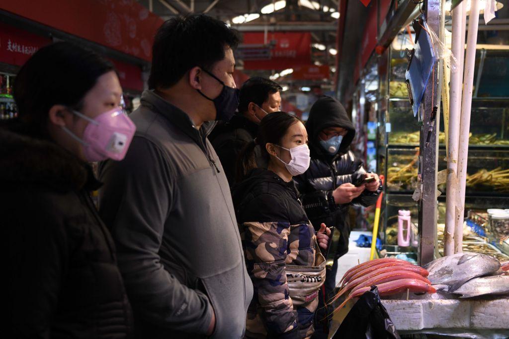 Local residents wear masks as they shop in a market in Beijing on Feb. 27, 2020. (Greg Baker/AFP via Getty Images)