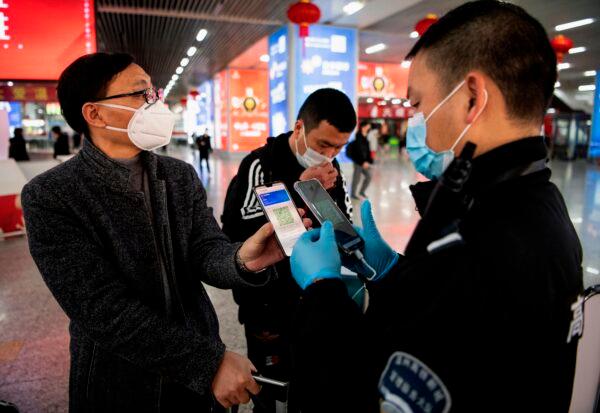 A passenger shows a green QR code on his phone to show his health status to security upon arrival at Wenzhou railway station in Wenzhou, Zhejiang on February 28, 2020. (Noel Celis/AFP via Getty Images)