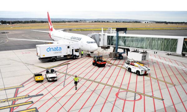 Baggage handlers load a Qantas plane at Adelaide Airport, Australia on April 1, 2020. (Tracey Nearmy/Getty Images).