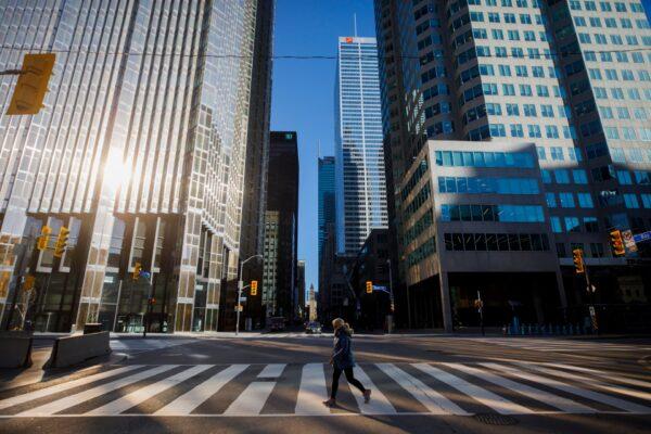 A woman crosses the street during morning commuting hours in the Financial District as Toronto copes with a shutdown due to the coronavirus, in Toronto, Canada, on April 1, 2020. (Cole Burston/Getty Images)