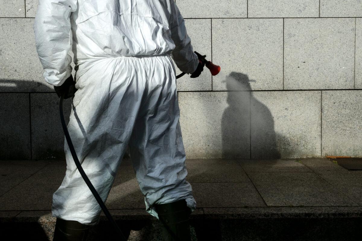 A cleaner wearing protective gear disinfects public areas in the village of Bueu, northwestern Spain, on April 2, 2020. (Miguel Riopa/AFP via Getty Images)