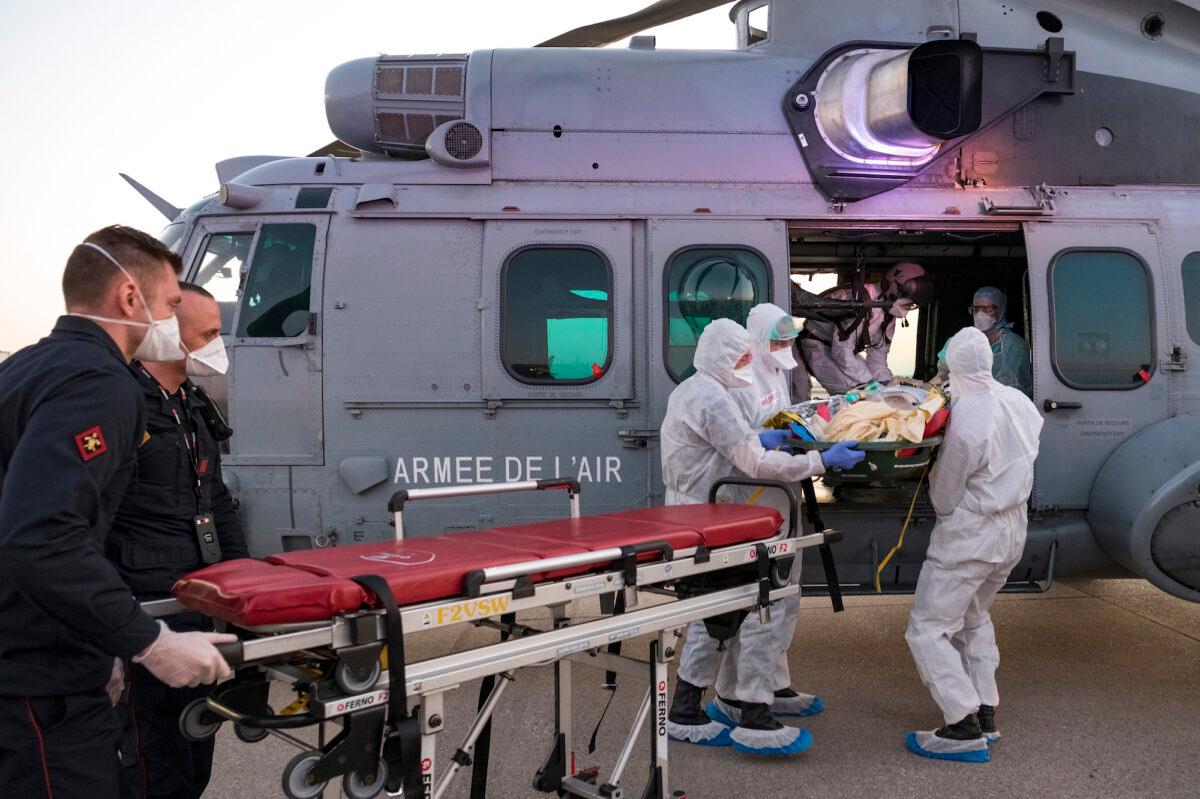Medics evacuate a COVID-19 patient at an airport near Paris on April 1, 2020. (Julien Fechter/Dicod via AP)