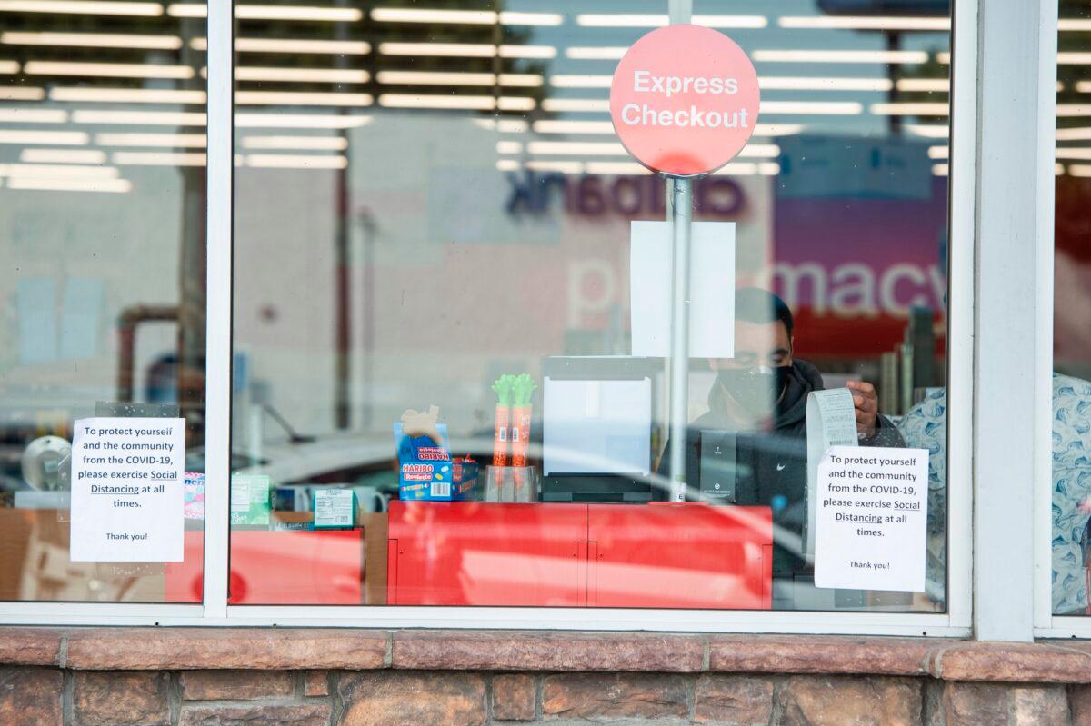 A person with a mask shops at CVS in Los Angeles, California on March 31, 2020. Pharmacies, grocery stores, and other businesses deemed essential are allowed to stay open amid the COVID-19 pandemic. (Valerie Macon/AFP via Getty Images)
