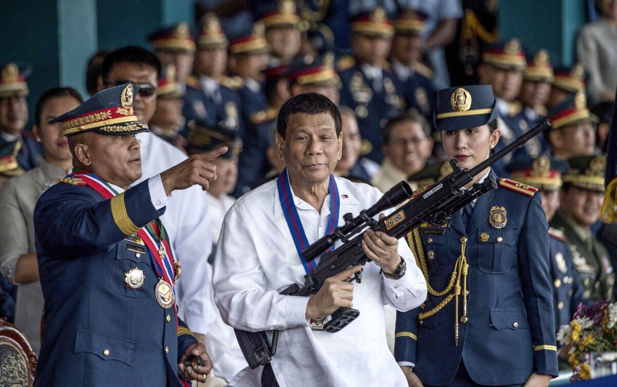 Philippine President Rodrigo Duterte holds a Galil sniper rifle with outgoing Philippine National Police (PNP) chief Ronald dela Rosa (L) during the change of command ceremony at Camp Crame in Manila on April 19, 2018. (Noel Celis/AFP via Getty Images)