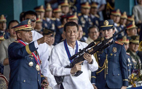 Philippines President Rodrigo Duterte holding a Galil sniper rifle with outgoing National Police (PNP) chief Ronald dela Rosa (L) during the change of command ceremony at Camp Crame in Manila on April 19, 2018. (Noel Celis/AFP via Getty Images)