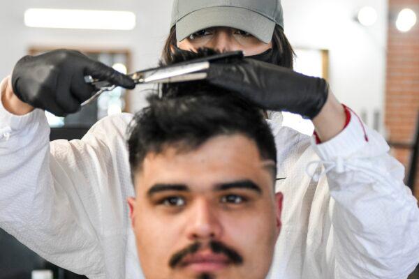 The Bar.Ber.Shop stylist Brenda Escobedo gives Alan Gomez a haircut in Greeley, Colo., on April 28, 2020. (Michael Ciaglo/Getty Images)