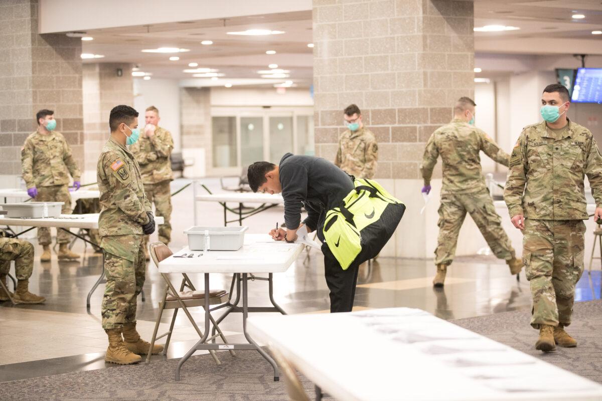 An arriving traveler fills out a form for the National Guard at TF Green Airport in Warwick, R.I., on March 29, 2020. (Scott Eisen/Getty Images)