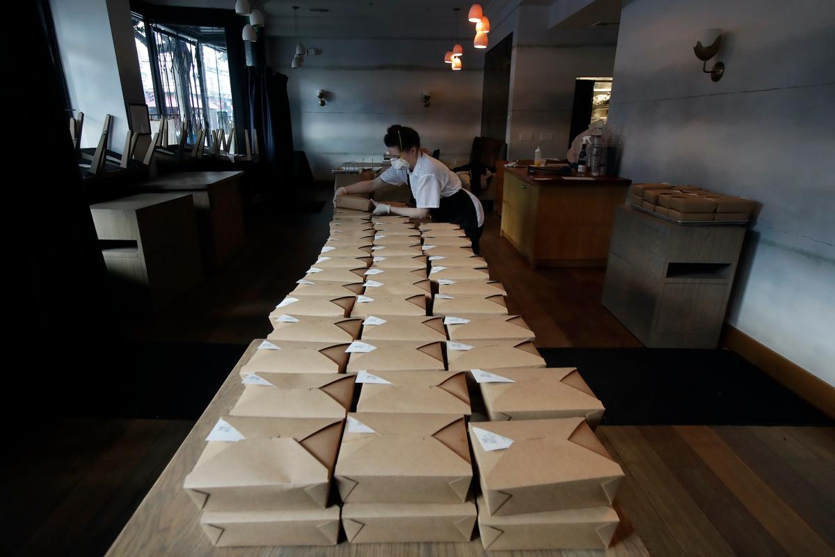 Nightbird Restaurant pastry chef Hope Waggoner prepares dinner boxes that were delivered to hospital workers in San Francisco. (AP Photo/Jeff Chiu)