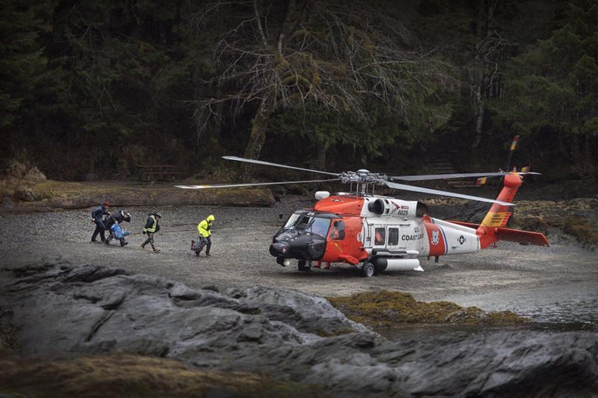 A U.S. Coast Guard helicopter sits in a beach area in order to airlift personnel with Ketchikan Volunteer Rescue Squad to a remote area of Lunch Creek, a state recreation site in Ketchikan, Alaska on Saturday, March 28, 2020. (Dustin Safranek/Ketchikan Daily News/AP)