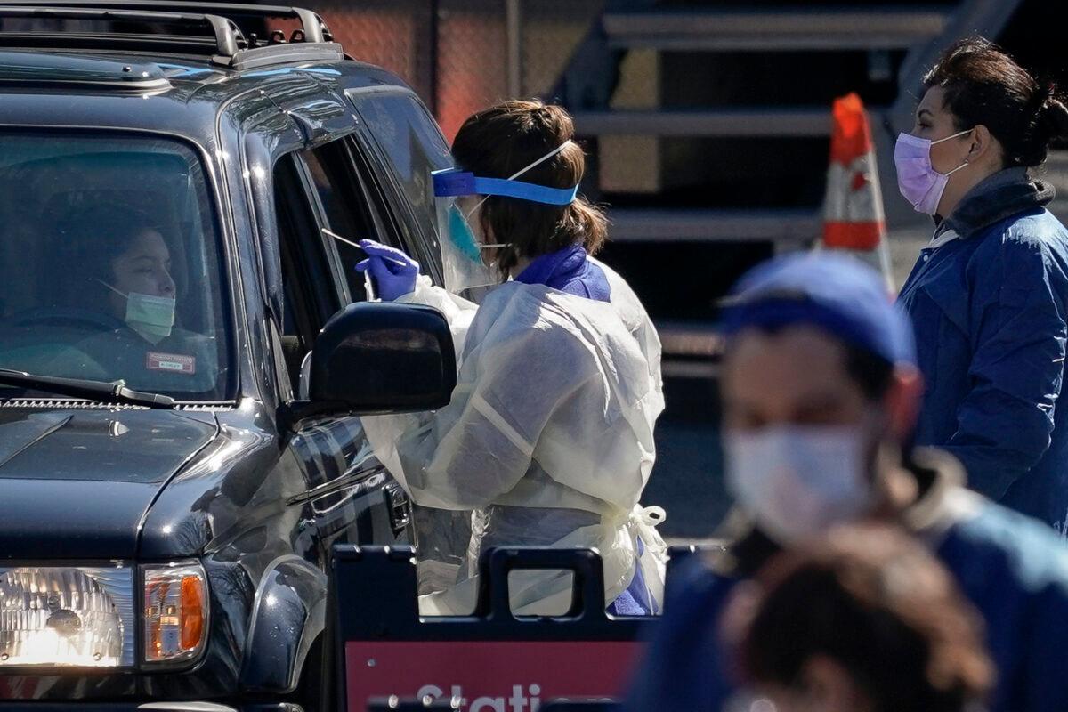 A medical professional from Children's National Hospital administers a coronavirus test at a drive-thru testing site for children age 22 and under at Trinity University in Washington on April 2, 2020. (Drew Angerer/Getty Images)