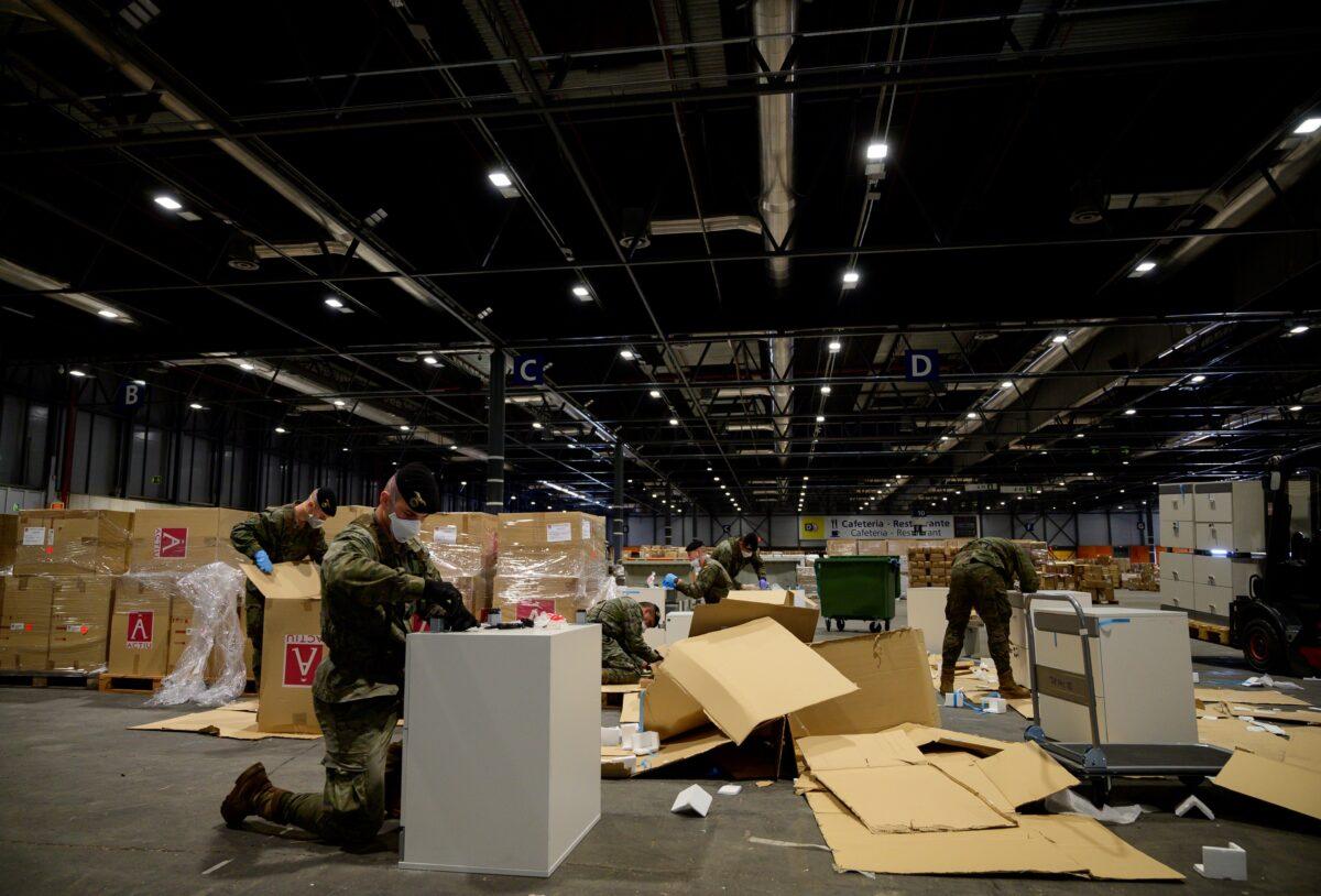Spanish soldiers open boxes of medical aid at the Ifema convention and exhibition centre in Madrid, Spain, where a temporary hospital for COVID-19 patients is located, on April 3, 2020. (Pierre-Philippe Marcou/AFP via Getty Images)