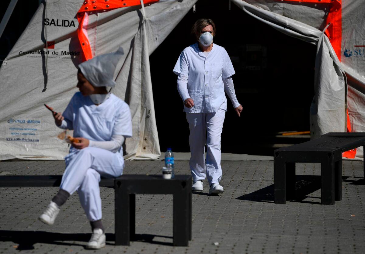 Health workers stand outside the Ifema convention and exhibition center in Madrid, Spain, where a temporary hospital for COVID-19 patients is located, on April 3, 2020. (Pierre-Philippe Marcou/AFP via Getty Images)