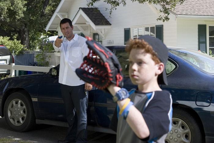 Michael Newman (Adam Sandler, L) uses his magic clicker to pause and then reposition the glove of the annoying neighbor-brat (Cameron Monaghan) so he gets beaned in the head with a baseball, in "Click." (Tracy Bennett/Revolution Studios Distribution Company, LLC/Columbia Pictures)
