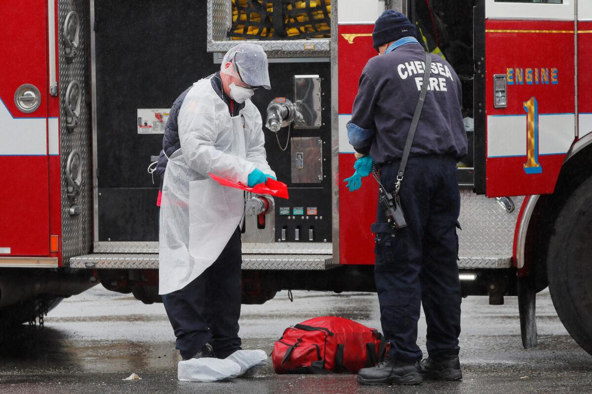 Firefighters remove personal protective equipment after responding to a medical call amid the COVID-19 outbreak in Chelsea, Massachusetts, on April 3, 2020. (Reuters/Brian Snyder)