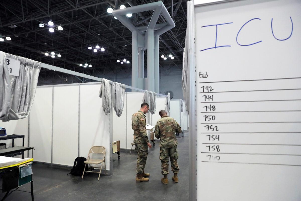Army medical personnel walk amongst cubicles in Javits New York Medical Station in New York City, on April 3, 2020. (Reuters/Andrew Kelly)