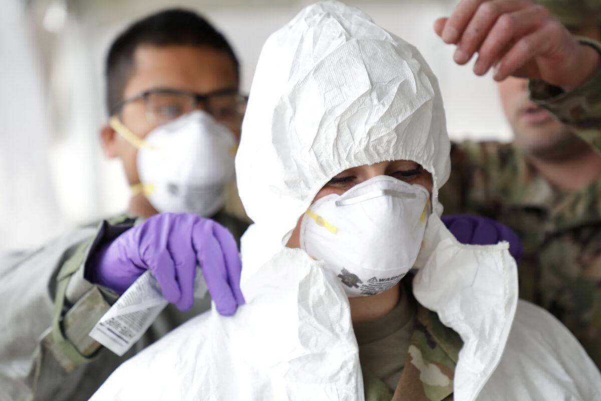 Rhode Island National Guard Sergeant Cora Brown is fitted with protective gear during training to administer CCP virus tests to the public in Warwick, Rhode Island, on March 30, 2020. (Air National Guard/Staff Sgt. John Vannucci/Handout via Reuters)