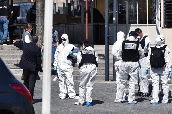 Police officers investigate after a man wielding a knife attacked residents venturing out to shop in the town under lockdown, in Romans-sur-Isere, southern France, on April 4, 2020. (AP Photo)