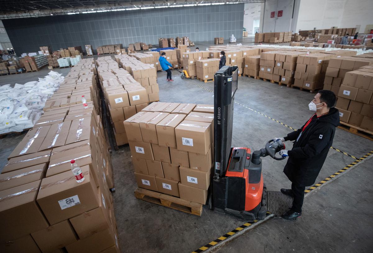 Staff members and volunteers transfer medical supplies at a warehouse of an exhibition center in Wuhan, China, on Feb. 4, 2020. (STR/AFP via Getty Images)