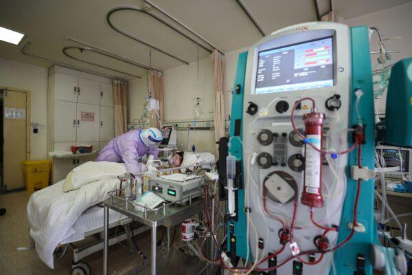 A patient infected by the COVID-19 coronavirus receiving treatment by extracorporeal membrane oxygenation (ECMO) at the Red Cross hospital in Wuhan, Hubei Province, China, on Feb. 28, 2020. (STR/AFP via Getty Images)