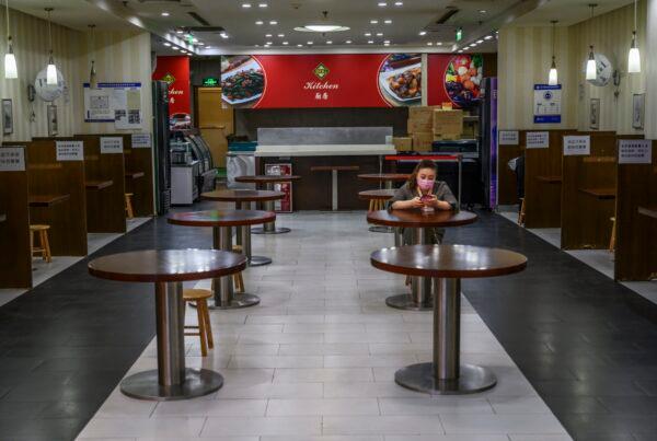 A Chinese woman waits for customers in a nearly empty restaurant at a shopping mall in Beijing, China on March 26, 2020. (Kevin Frayer/Getty Images)