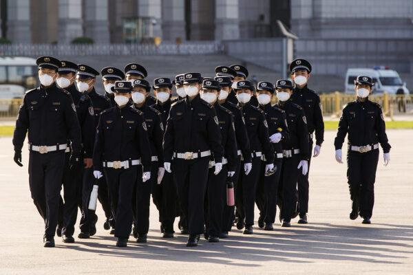 Chinese security personnel wearing protective masks march through Tiananmen Square in Beijing on April 4, 2020. (Lintao Zhang/Getty Images)