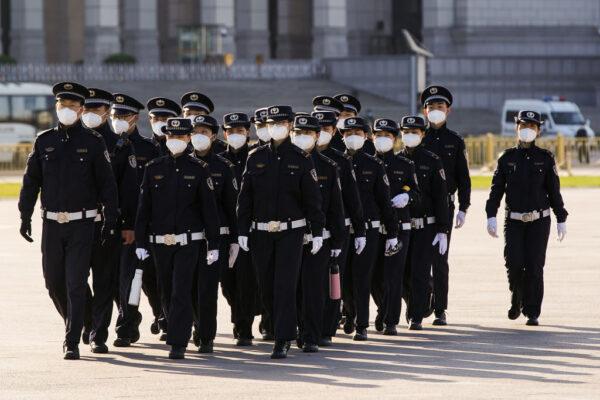 Chinese security personnel wearing protective masks march through Tiananmen Square during a national mourning to victims of COVID-19 in Beijing on April 04, 2020. (Lintao Zhang/Getty Images)