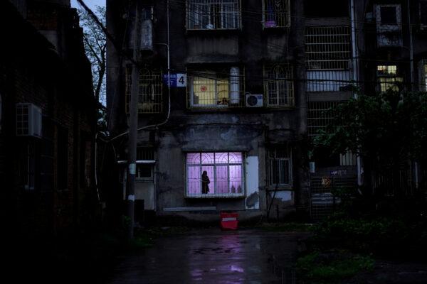 A man stands at a window at a residential community in Jingzhou, after the lockdown was eased in Hubei province, the epicenter of China's coronavirus disease (COVID-19) outbreak, March 26, 2020. (Aly Song/Reuters)