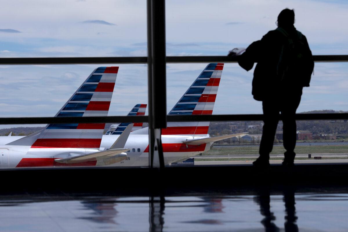 American Airlines planes are seen while a passenger waits for boarding at the Reagan International Airport in Washington, DC, on April 3, 2020. (Reuters/Carlos Barria)