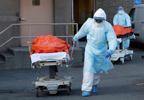 Healthcare workers wheel the bodies of deceased people from the Wyckoff Heights Medical Center during the outbreak of COVID-19 in New York City, New York, on April 4, 2020. (Reuters/Andrew Kelly)