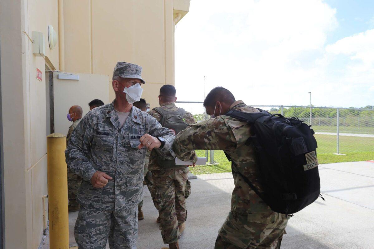 Maj. Dennis Kirkland, Guam National Guard state chaplain, greets Soldiers preparing to process through medical and customs checks at the GUNG readiness center after arriving on island April 5. (U.S. Army National Guard photo by JoAnna Delfin)