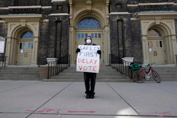 Jim Carpenter protests Tuesday's scheduled election amid the CCP virus pandemic , in downtown Milwaukee, on April 6, 2020. (Morry Gash/AP)