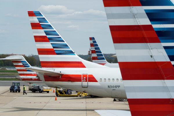 A member of a ground crew walks past American Airlines planes parked at the gate during the COVID-19 pandemic at Ronald Reagan National Airport in DC. on April 5, 2020. (Joshua Roberts/Reuters)