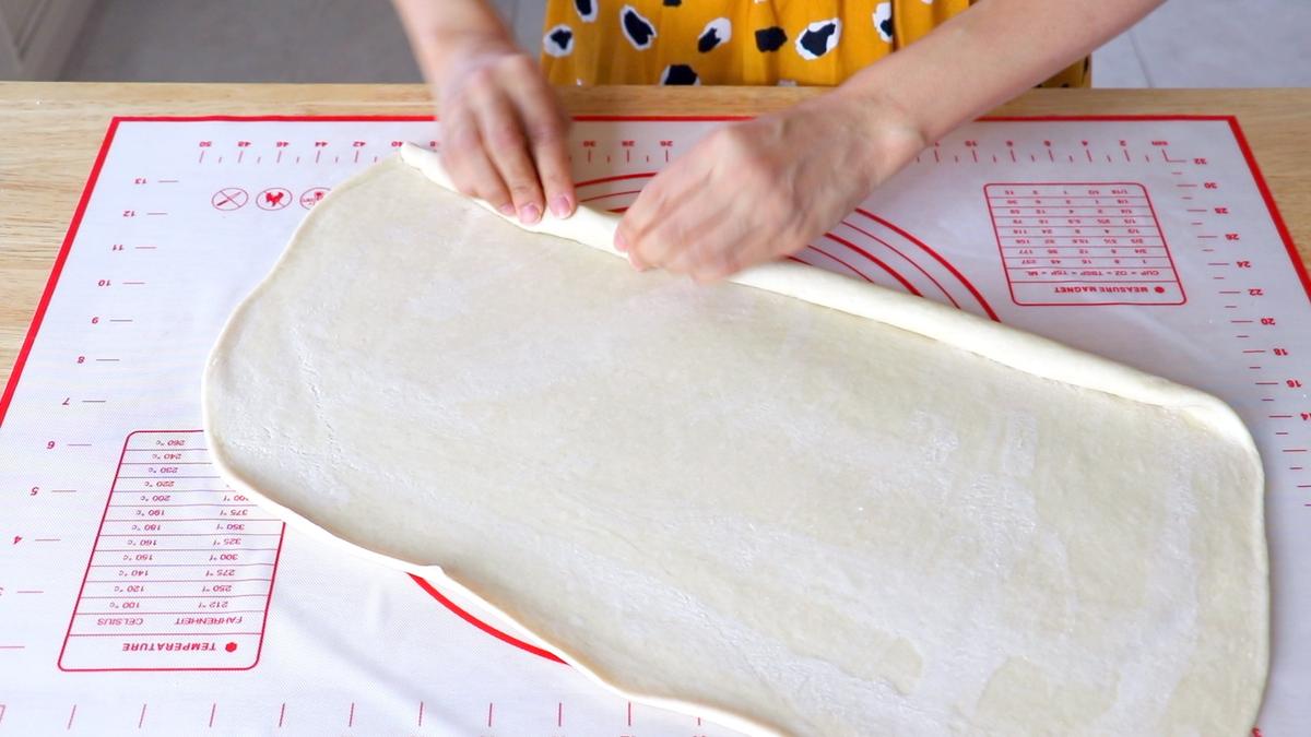 Rolling the rectangle of dough up into a log. (CiCi Li)