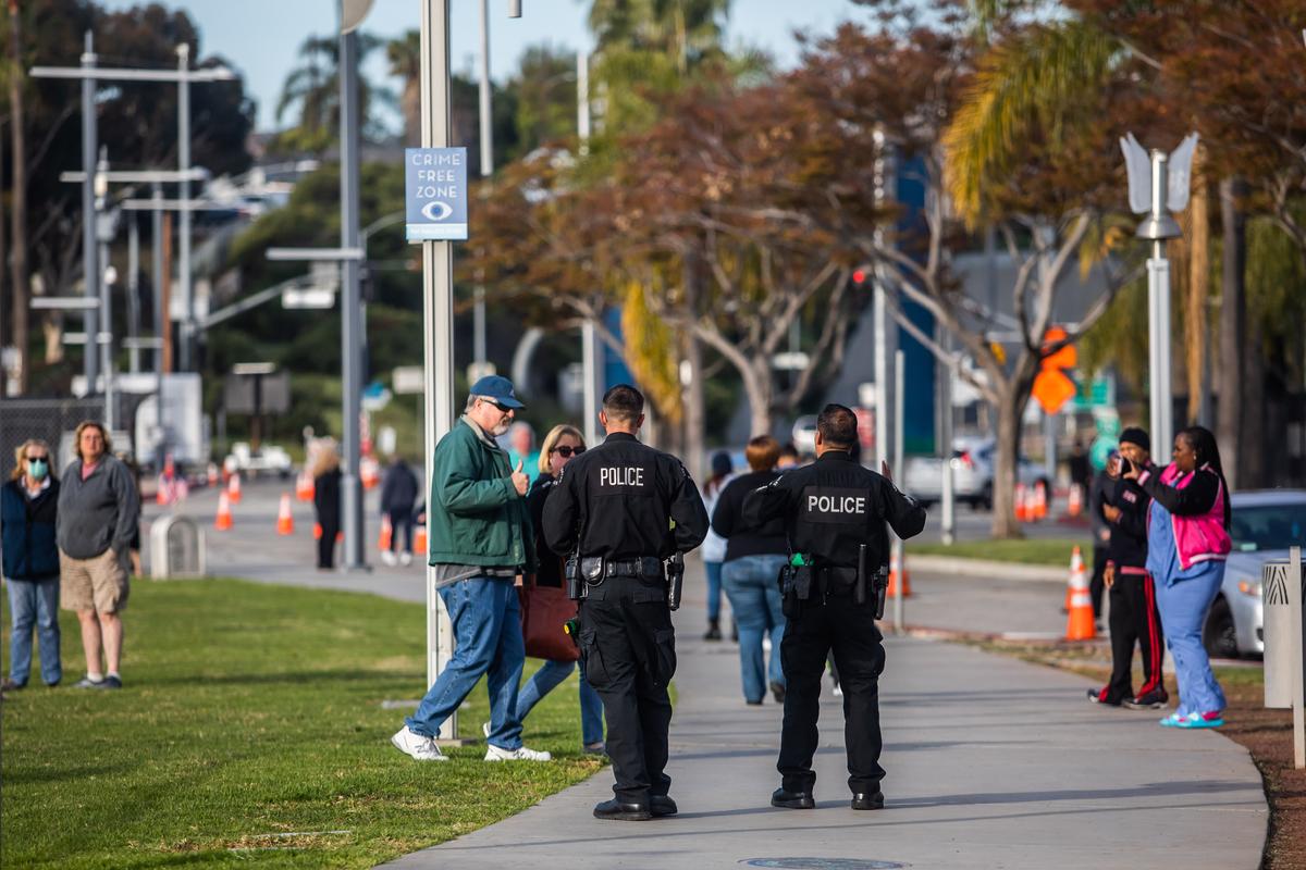 Police officers escort the public during a gathering to see the U.S. Navy Hospital ship "Mercy" at the Port of Los Angeles in San Pedro, California, on March 28, 2020. (©Getty Images | <a href="https://www.gettyimages.com/detail/news-photo/police-officer-talks-on-his-radio-while-escorting-people-news-photo/1208474426?adppopup=true">APU GOMES</a>)