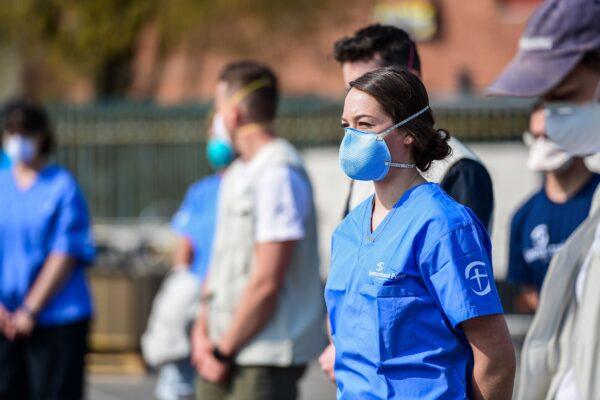 Volunteers looking on during the opening of a newly operative field hospital for coronavirus patients in Cremona, southeast of Milan on March 20, 2020. (Miguel Medina/AFP via Getty Images)