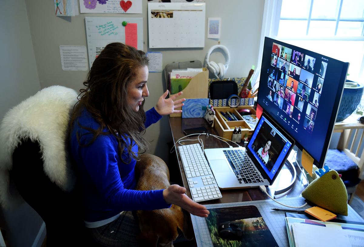 Lauryn Morley, a lower school substitute teacher for the Washington Waldorf School in Bethesda, Maryland, talks to Clare Andre (laptop), a 7th grade teacher and co-chair of the lower school, from her home due to the CCP virus outbreak in Arlington, Va., on April 1, 2020. (Olivier Douliery/AFP via Getty Images)