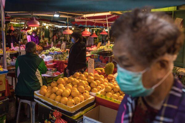 Vendors wearing face masks, amid concerns of the COVID-19 coronavirus, wait for customers at a fresh food market in Hong Kong, China, on April 5, 2020. (Dale De La Rey/AFP via Getty Images)