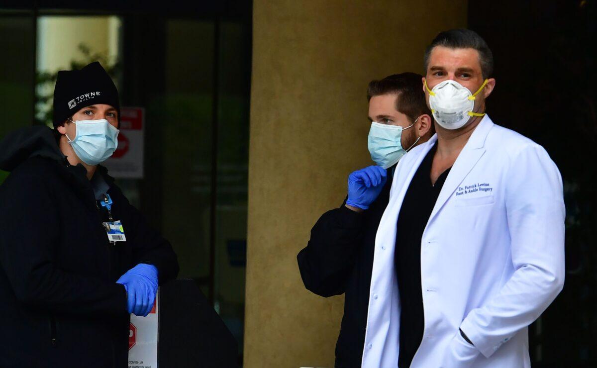 Medical personnel in facemasks are seen outside a hospital in Burbank, California on April 7, 2020. (Frederic J. Brown/AFP via Getty Images)