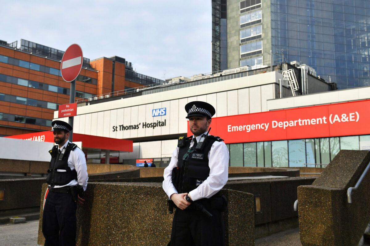 Police officers stand outside St Thomas' Hospital in the background in central London, where Prime Minister Boris Johnson remains in intensive care as his CCP virus symptoms persist, on April 8, 2020. (Dominic Lipinski/PA via AP)