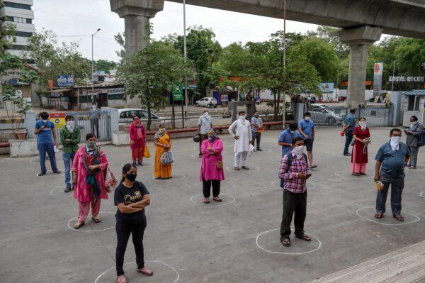 Customers stand on circles marked on the ground to maintain social distance as they wait to enter the Reliance Mart mall in Ahmedabad, India, on March 26, 2020. (Sam Panthaky /AFP via Getty Images)