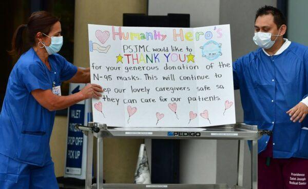 Hospital personnel display a thank you card after U.S. businessperson Michael "BigMike" Straumietis donated masks to the Providence Saint Joseph Medical Center in Burbank, Calif., on April 7, 2020. (Frederic J. BROWN/AFP via Getty Images)